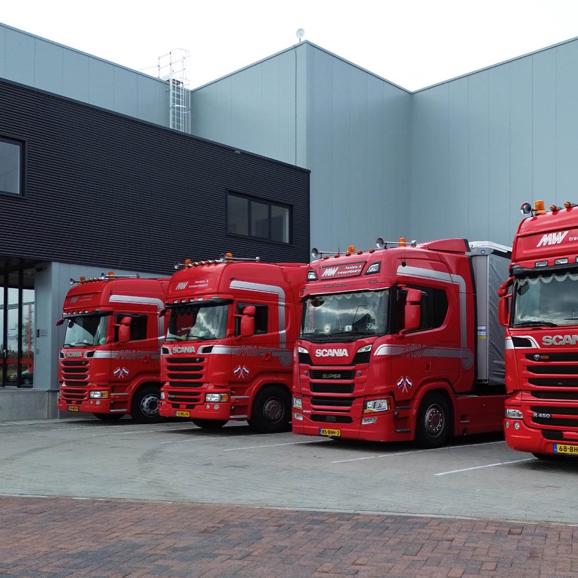 Rode vrachtwagen van Mostert & van de Weg